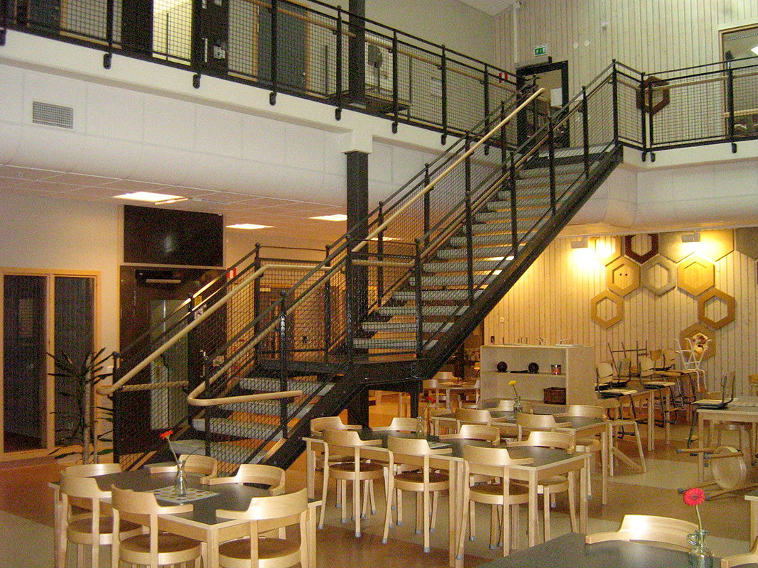 Raka trappor design – Trappa med terrazzosteg, räcke med nät och trähandledare.